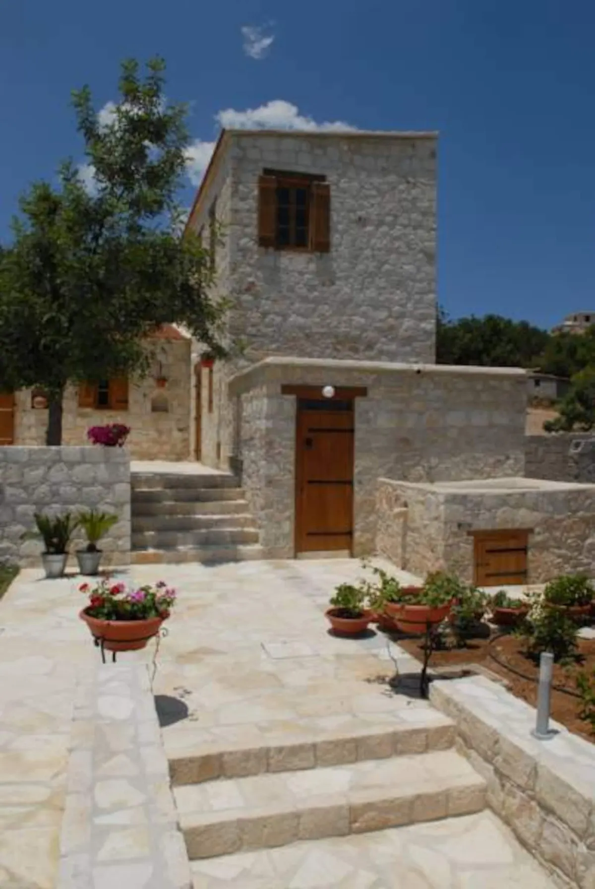 Stone tower house with wooden shutters and steps