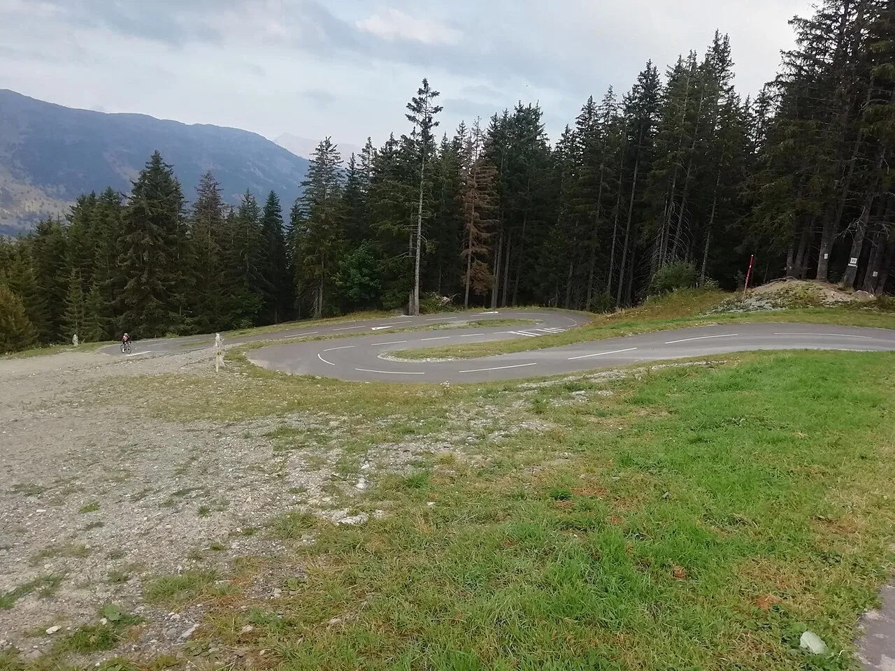 The narrow cycle-path hairpins of the Col de la Loze with a cyclist climbing